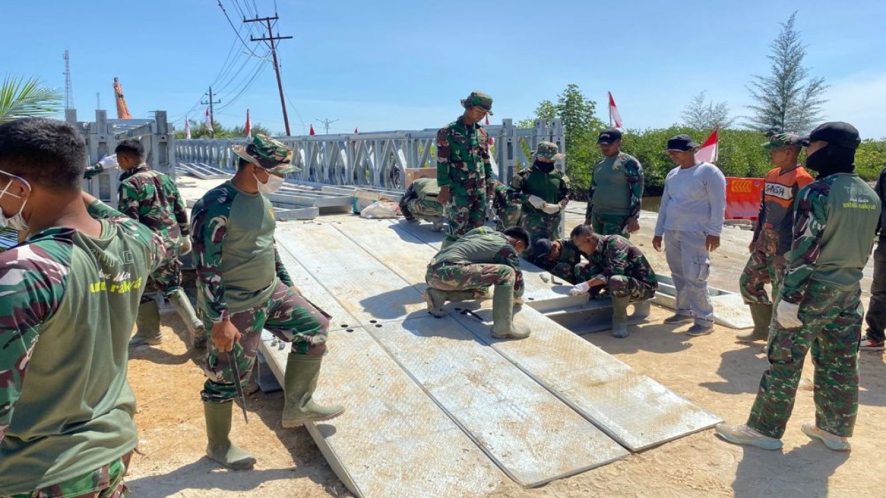 Sejumlah personel TNI tampak bergotong royong menyambungkan rangka baja jembatan bailey. (Foto: Dok/Istimewa)