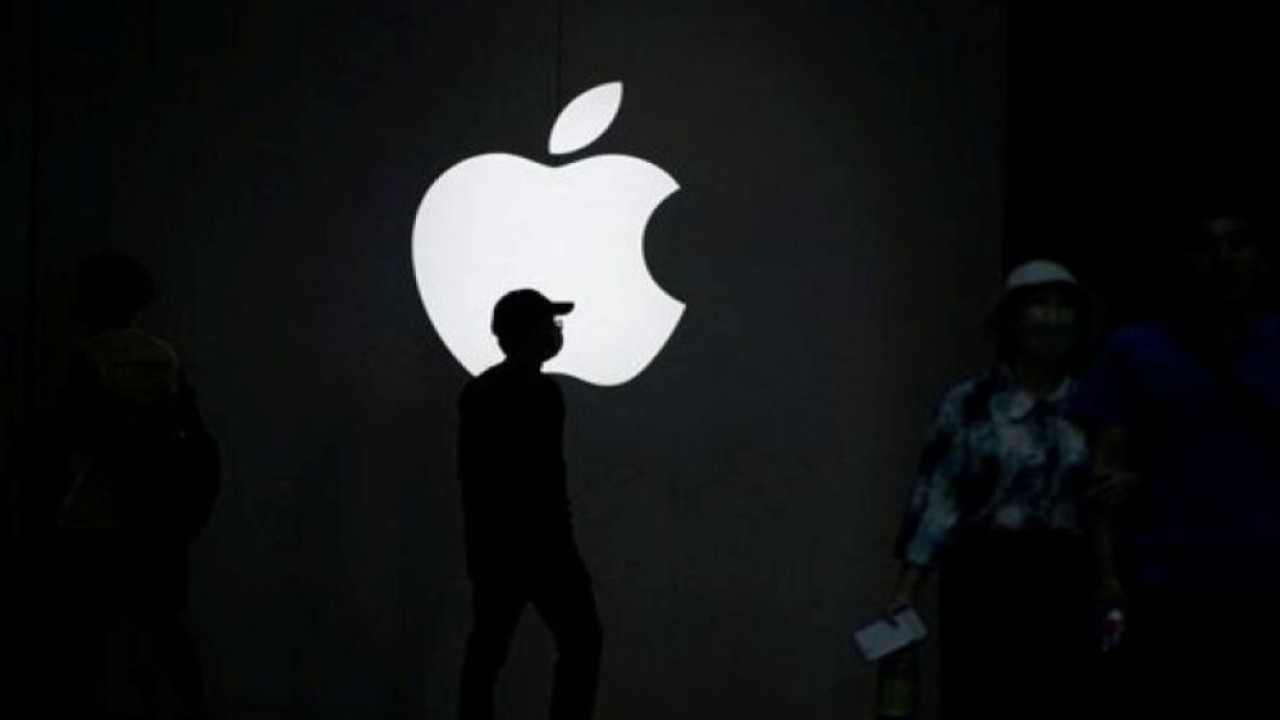 Sejumlah orang berjalan di dekat logo Apple di luar gerai di Shanghai, China, 8 September 2023. (Foto: Dok/Aly Song/Reuters)